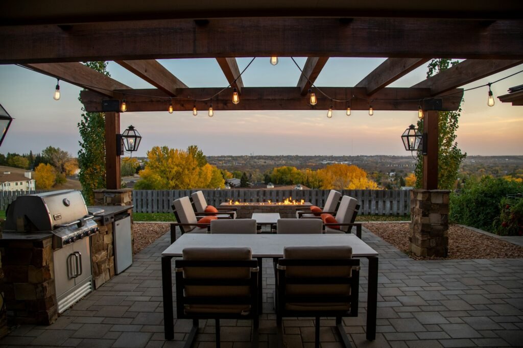 Built-in grill island under pergola on paver patio at dusk