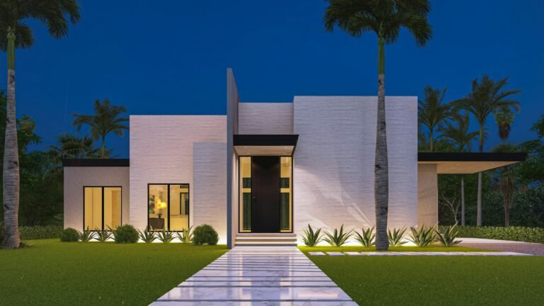 Modern white home with lit walkway and lawn at dusk