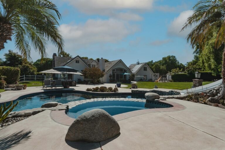 Freeform pool with boulders and concrete deck