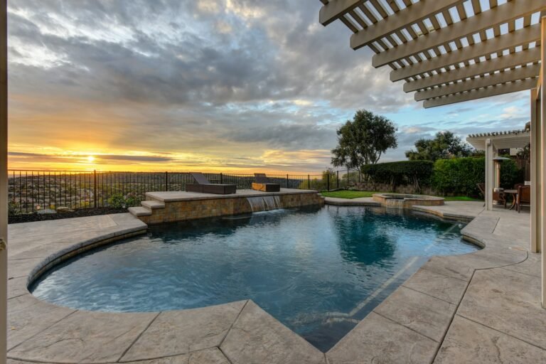 Pool with sunset view under a white pergola