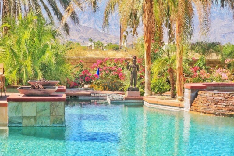 Resort-style pool with fire bowls, palms and mountain views
