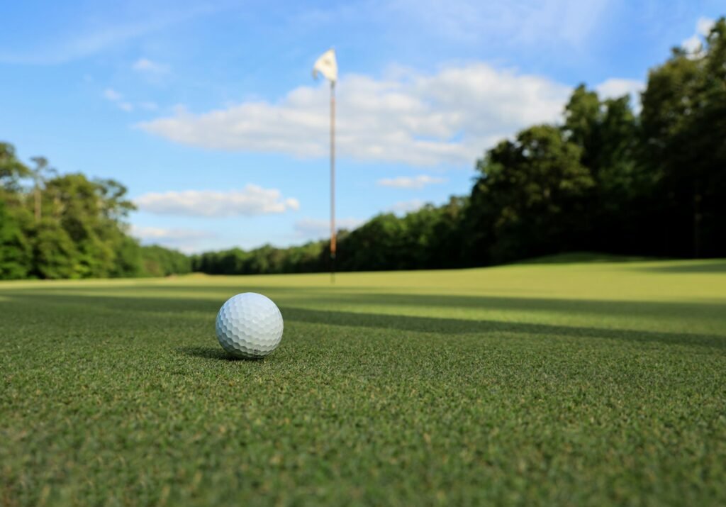 Golf ball on a smooth putting green near the flag