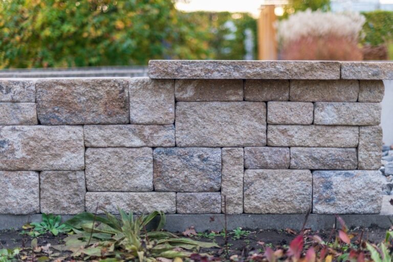 Segmental stone block retaining wall with capstones